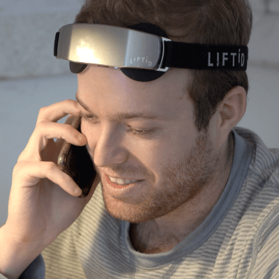 Man Wearing LIFTiD Neurostimulation tDCS device While on Phone